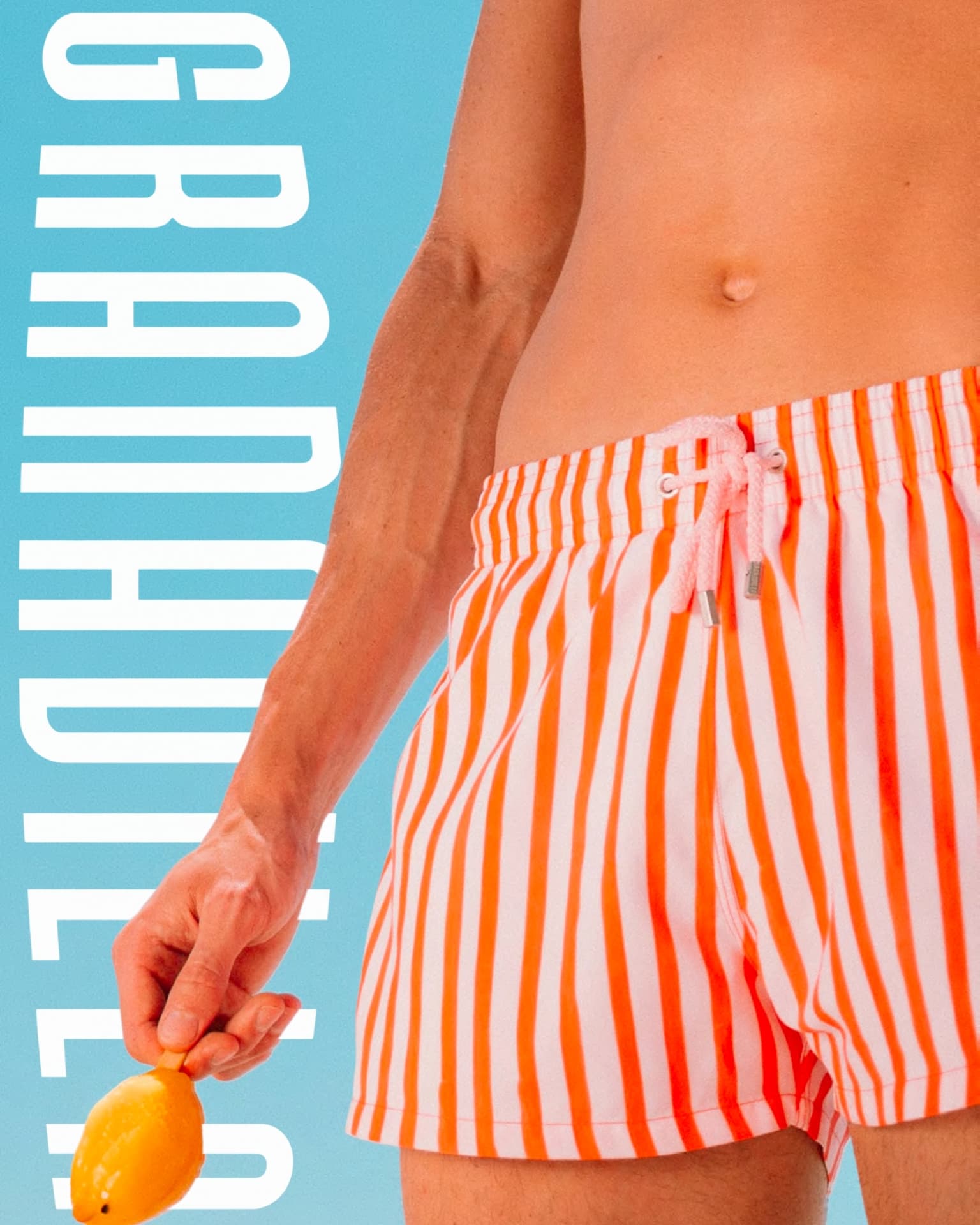 Orange striped Granadilla swim shorts against a blue backdrop with the wordmark