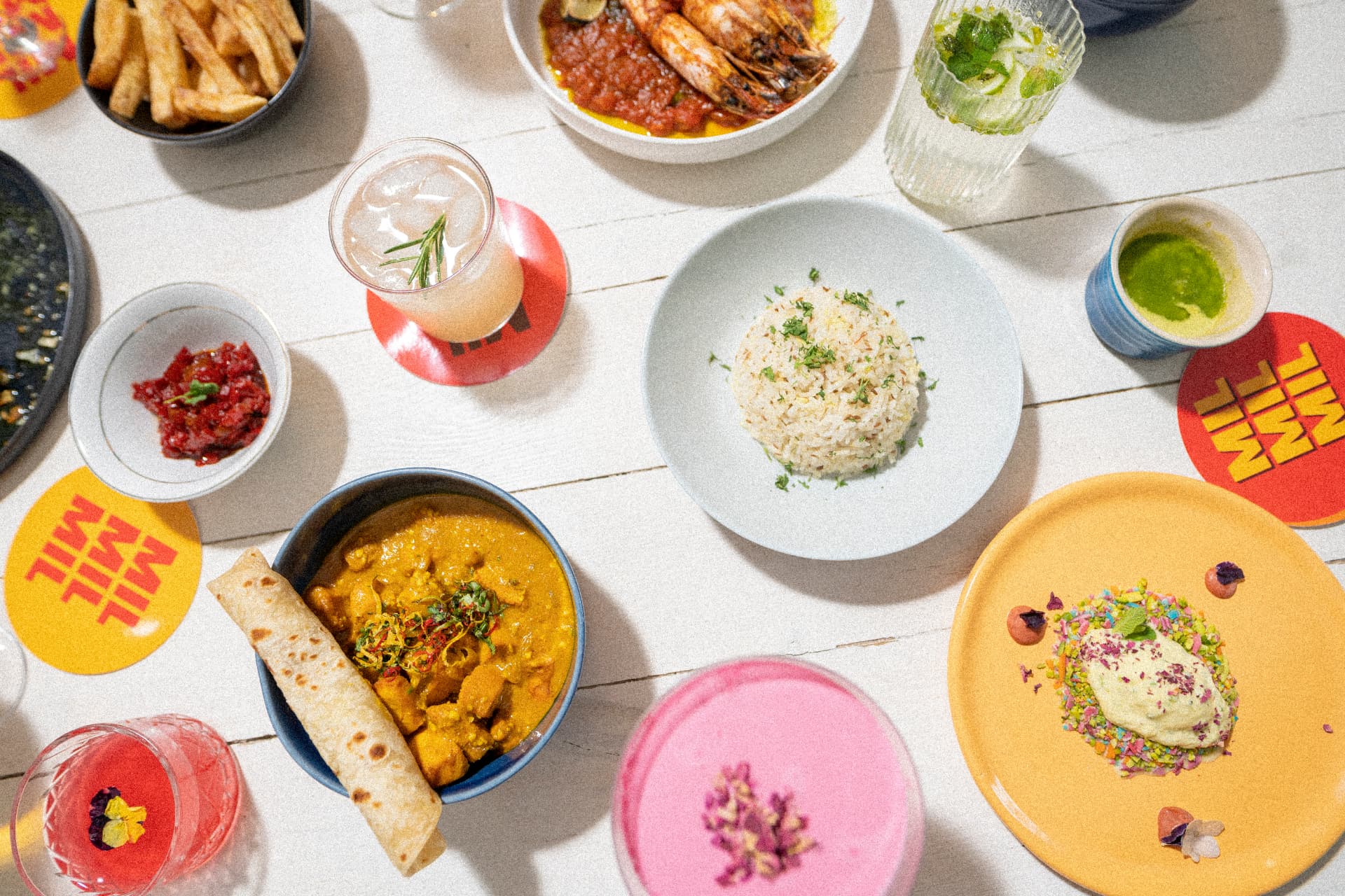 Overhead shot of a Mother In Law table of curries, prawns and cocktails