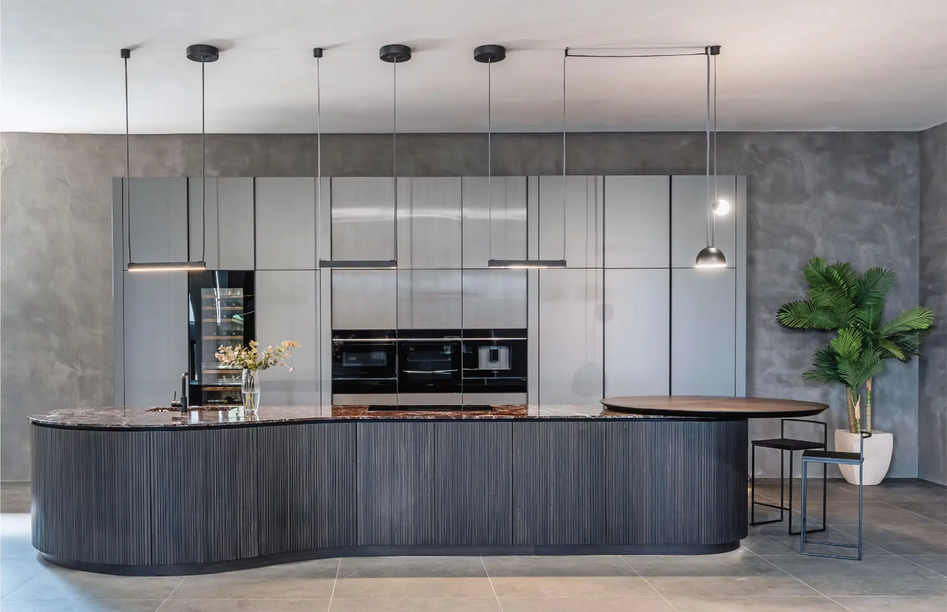 The Kitchen Studio showroom kitchen with a curved fluted island and marble top