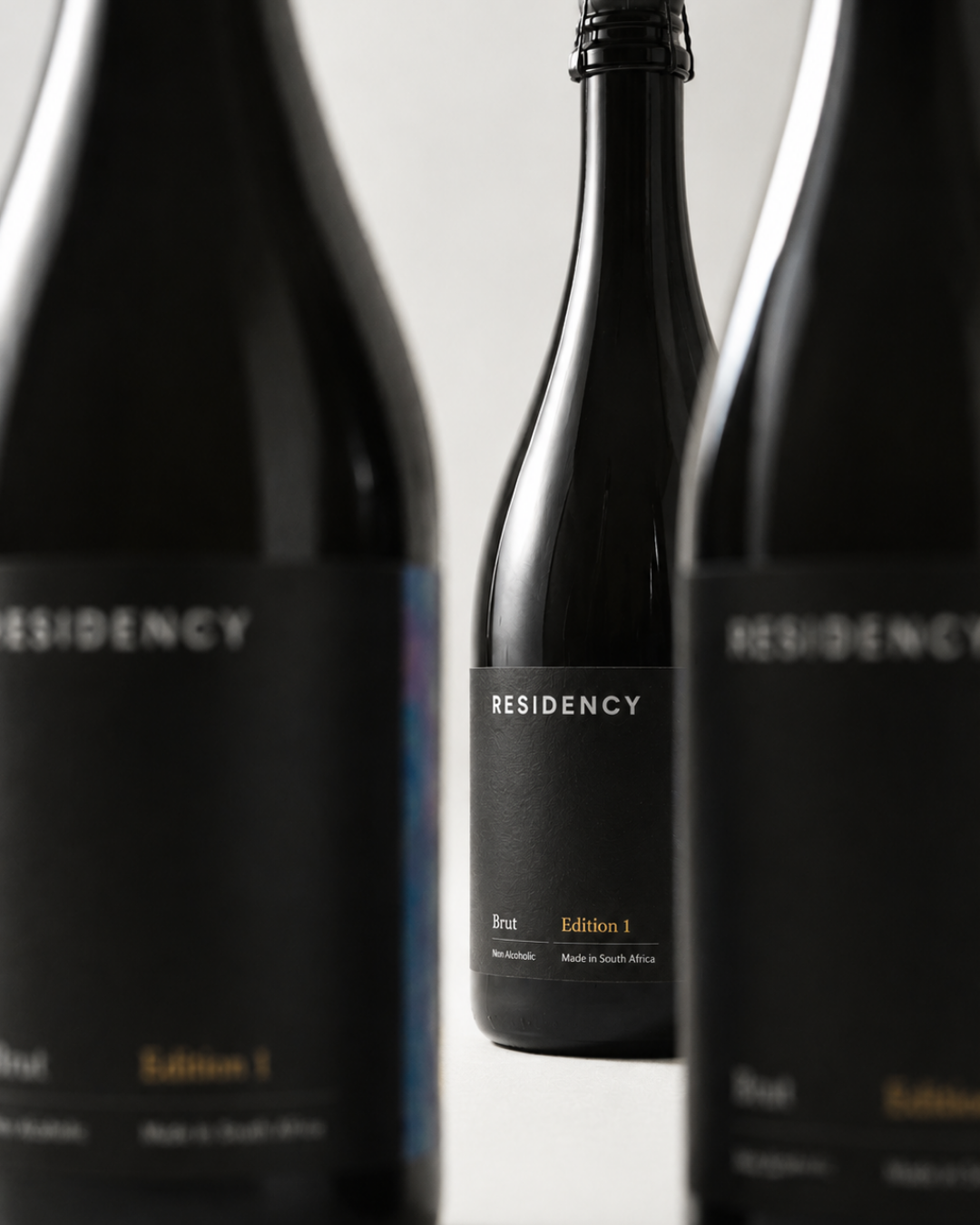Three Residency Brut Edition 1 bottles with matte black labels, the centre one in focus